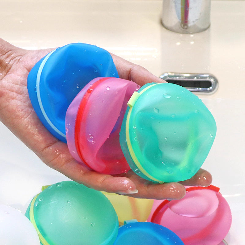 Colorful silicone empty water balloons held in a hand with a sink background